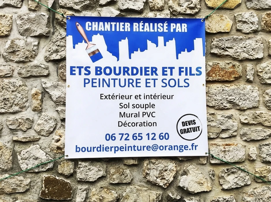 Panneau publicitaire en bâche vinyle bleu et blanc fixé sur un mur en pierre apparente
