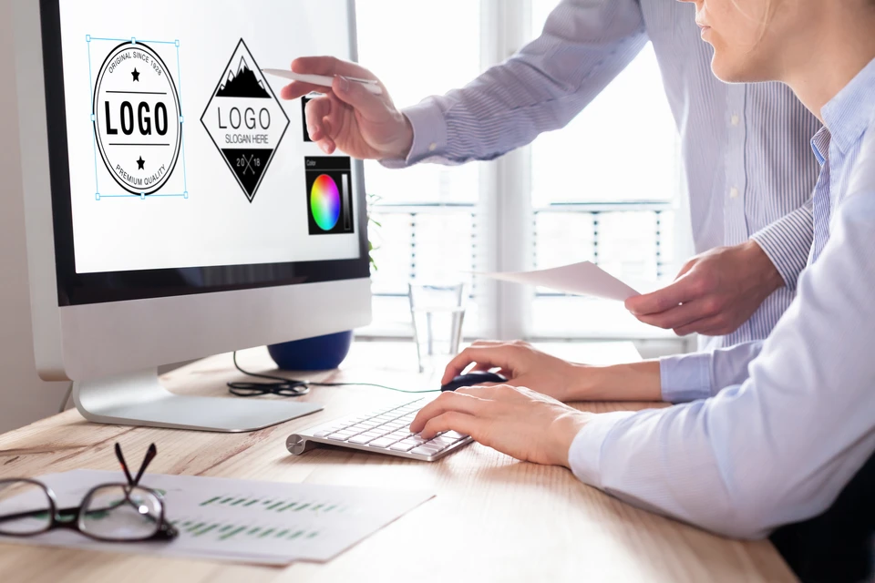 Deux professionnels collaborent dans un bureau moderne sur la création de logos