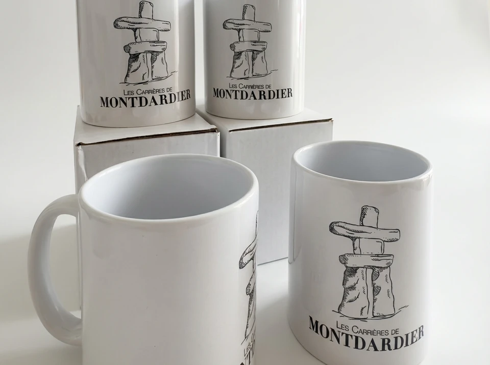 Photographie professionnelle en gros plan ou semi-gros plan d'un assortiment cohésif de 5 à 8 objets publicitaires personnalisés avec marquage visible et diversifiés : par exemple des gourdes, des carnets avec logo, des porte-clés, des badges, des bracelets gravés, présentés en arrangement naturel sur une surface neutre (bois clair ou gris) avec une mise en lumière douce qui met en valeur les finitions et les détails de personnalisation.