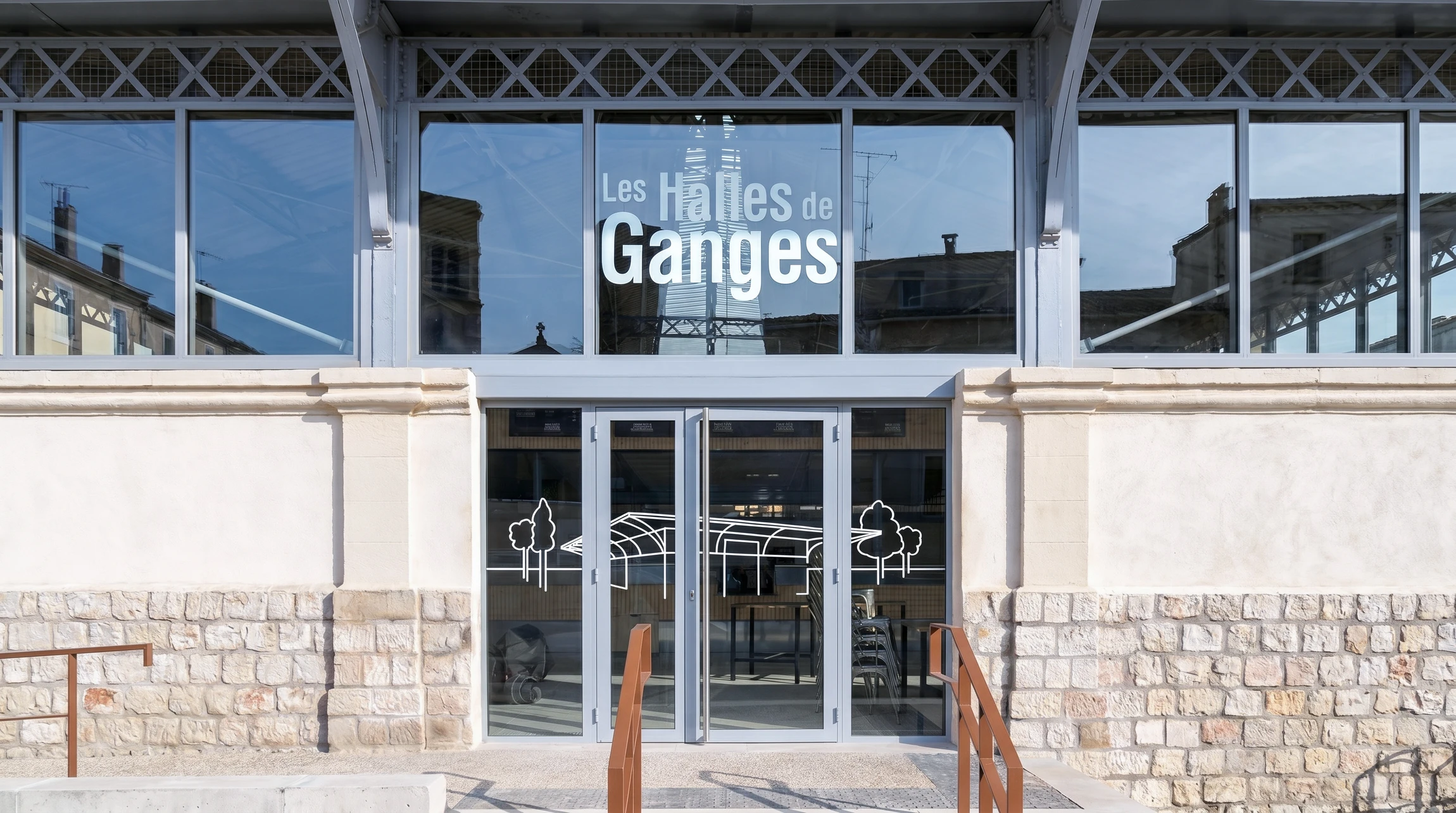 Enseigne commerciale blanche en relief avec lettres tridimensionnelles "shop" suspendue à une potence métallique noire sur façade urbaine
