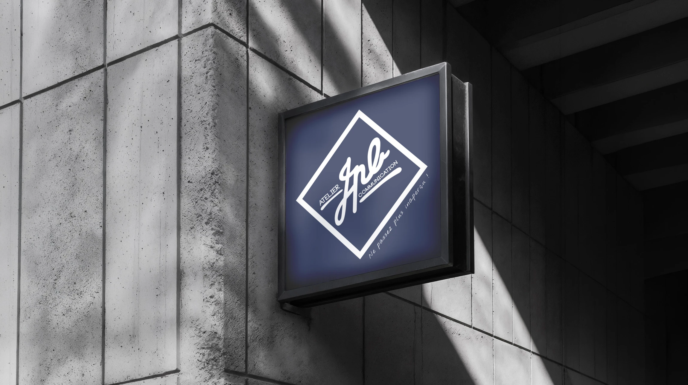 Enseigne commerciale blanche en relief avec lettres tridimensionnelles "shop" suspendue à une potence métallique noire sur façade urbaine