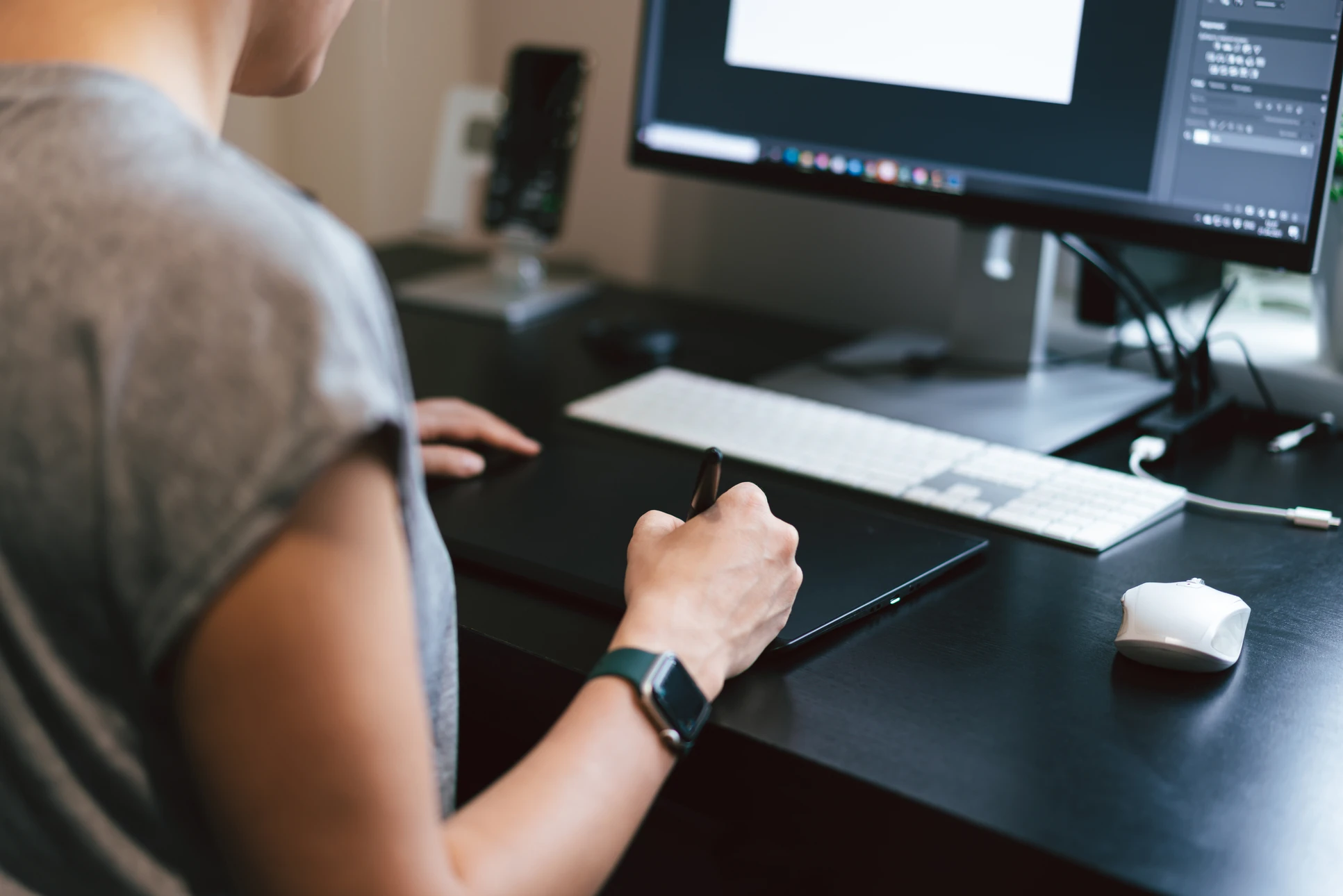 Espace de travail créatif intérieur avec personne utilisant tablette graphique et stylet