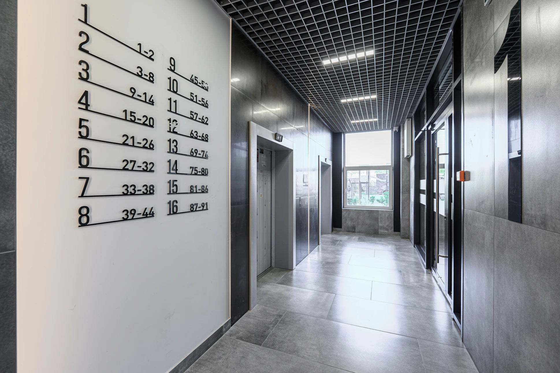Façade extérieure d'un établissement commercial avec enseigne "CAFÉ" en lettres capitales blanches sur fond noir mat