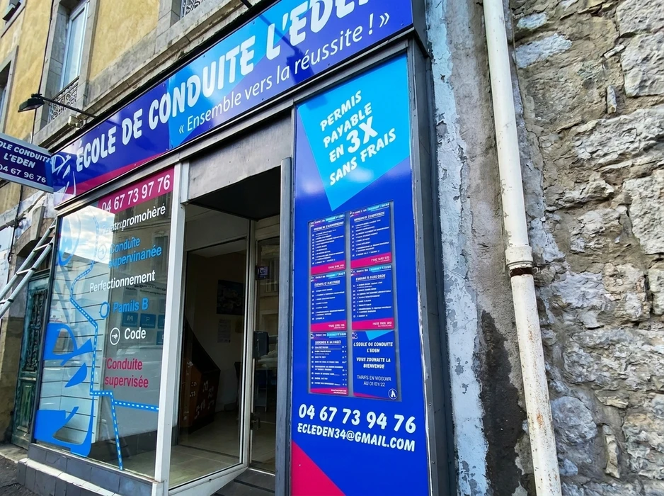 Façade extérieure d'établissement hôtelier avec enseigne lumineuse trois étoiles montée sur mur sombre