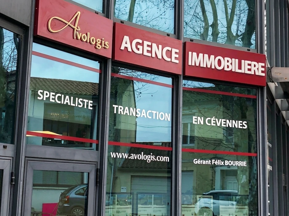 Façade extérieure d'établissement hôtelier avec enseigne lumineuse trois étoiles montée sur mur sombre
