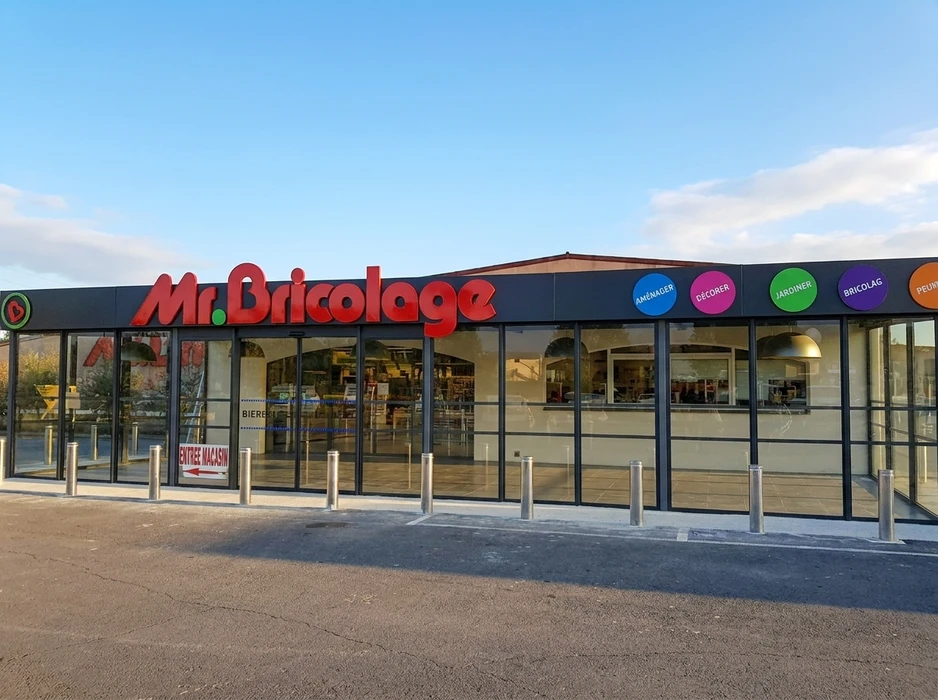 Façade extérieure d'établissement hôtelier avec enseigne lumineuse trois étoiles montée sur mur sombre